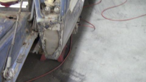 1979 Ford Bronco - Close-up view of a heavily rusted and damaged vehicle body panel, indicating significant wear and tear.