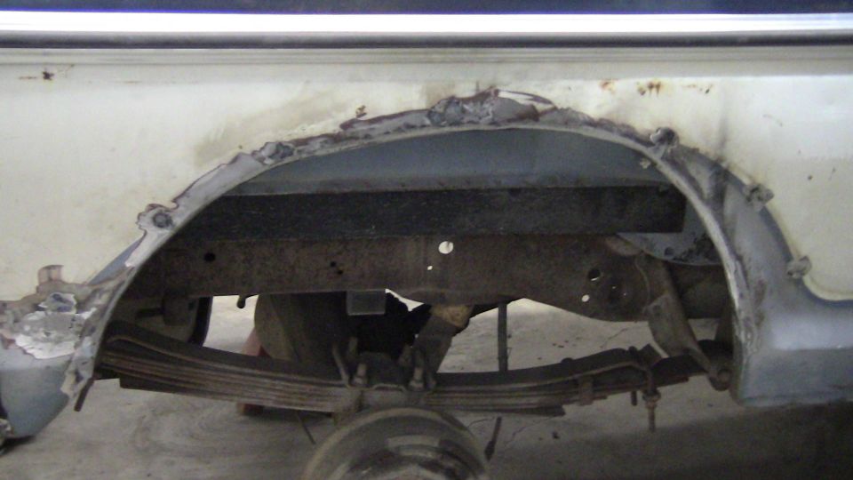 Rear wheel well and suspension of a vehicle with significant rust damage