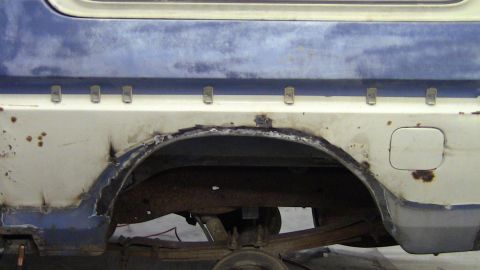 1979 Ford Bronco - Close-up of the rear wheel arch on a 1979 Ford Bronco, showing significant rust and body damage.