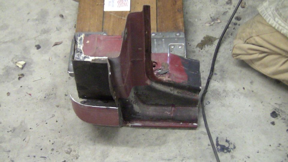 Maroon and black car fender section with chrome trim, viewed from the side