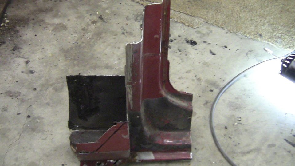 Maroon metal car part on concrete floor