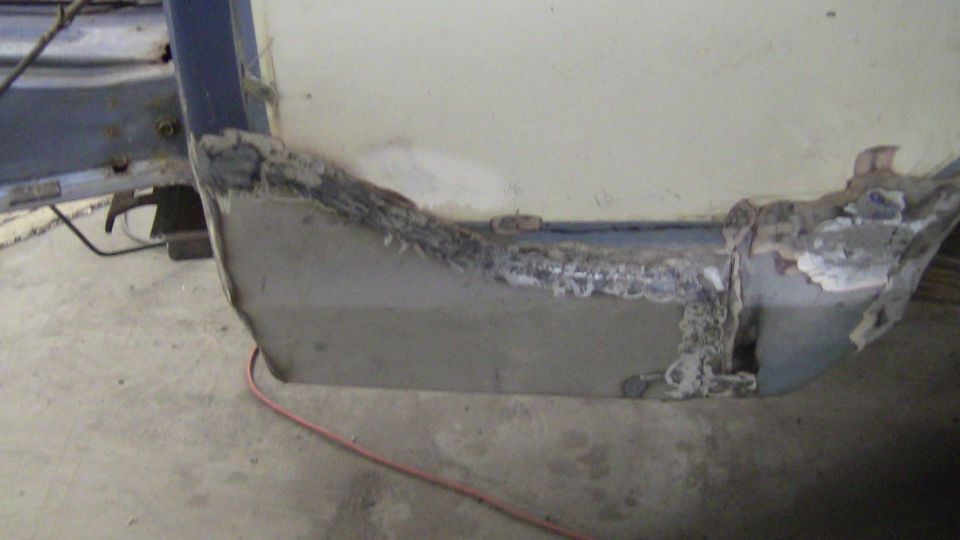 Rusted metal panel with welding marks, part of a vehicle repair