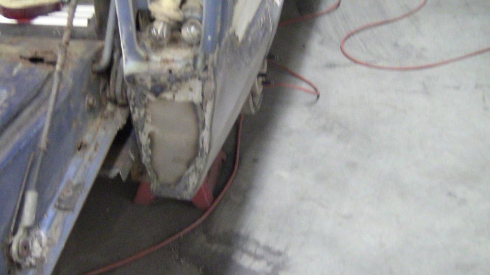 rusted vehicle body panel with visible damage and repair work