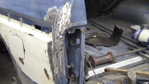 1979 Ford Bronco - This vehicle's quarter panel shows significant rust damage and is undergoing repair.