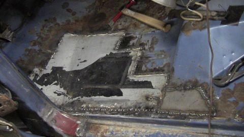 1979 Ford Bronco - The floor of a vehicle is undergoing repair with welded metal patches to address rust damage.
