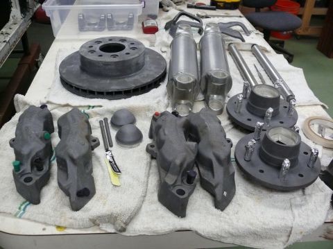 Brake rotors, calipers, shocks, and hubs laid out on a towel