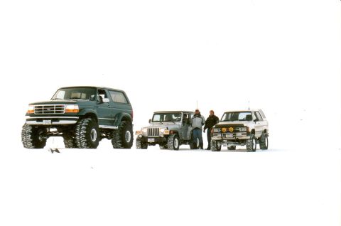 1996 Ford Bronco - A dark green 1992 Ford Bronco is parked in the snow alongside two other vehicles.