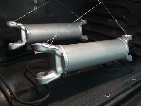 two driveshafts hanging by wires