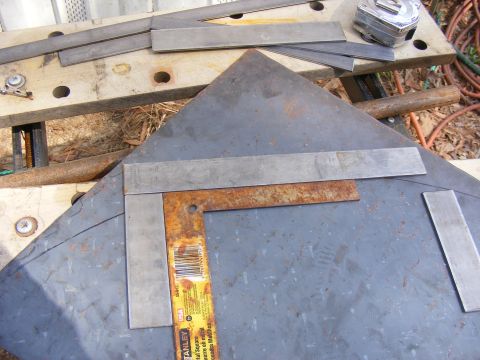 Metal square and ruler on a large sheet of metal, with smaller metal strips and a tape measure nearby