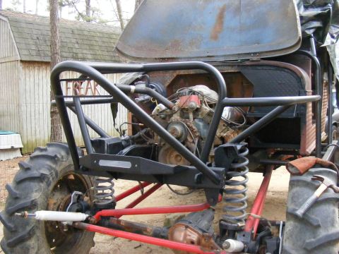 Custom off-road vehicle with large tires, exposed engine, and roll cage. Text 'FREAK' visible on cage