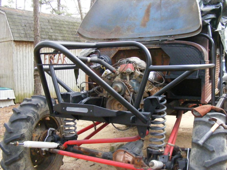 Custom off-road vehicle with large tires, exposed engine, and roll cage. Text 'FREAK' visible on cage