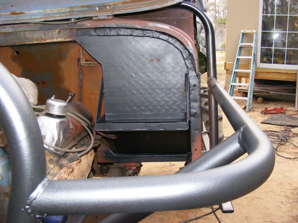 Custom metal box installed in a vehicle's interior, near the engine and roll cage
