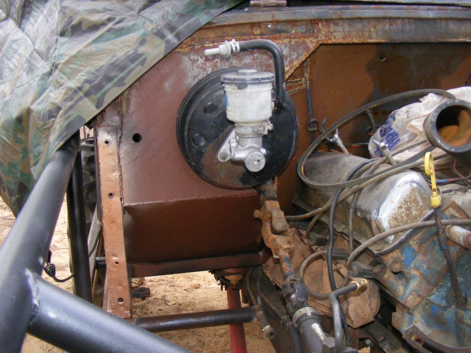 Brake master cylinder and engine components under camouflage tarp