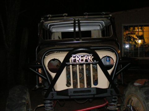 Front view of custom off-road vehicle with "FREAK" text on grille and large tires