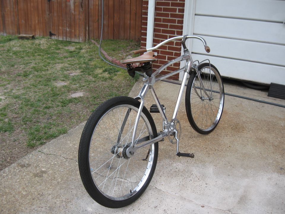 Chrome cruiser bicycle with leather seat and wide handlebars parked on concrete