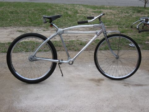 Silver bicycle side view with black seat and handlebars