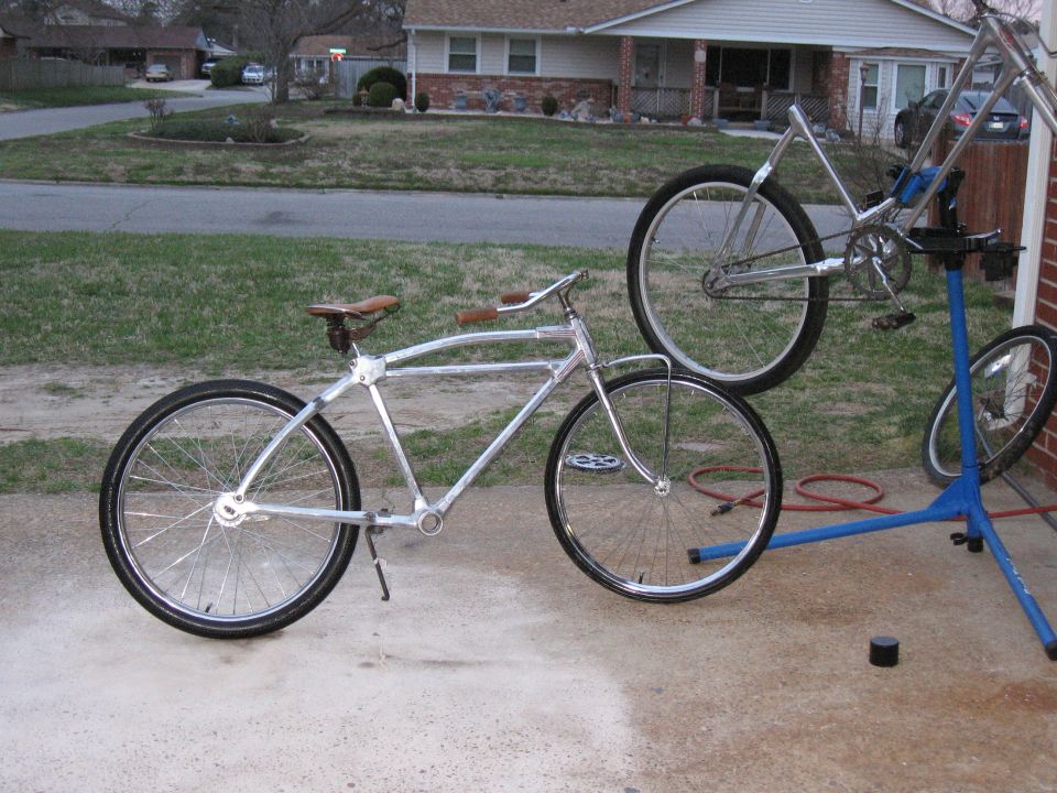 Two bicycles, one on a repair stand, in a driveway