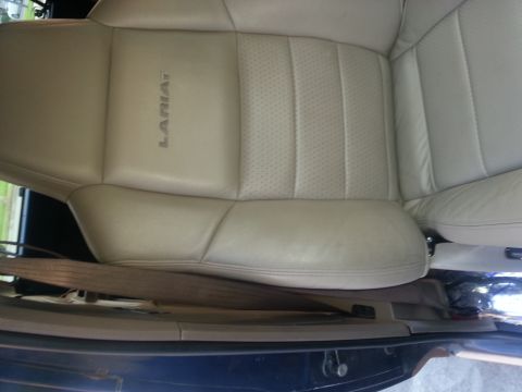 1994 Ford Bronco - Close-up of a tan leather car seat with 'LARIAT' embossed on the side. Seatbelt is visible.