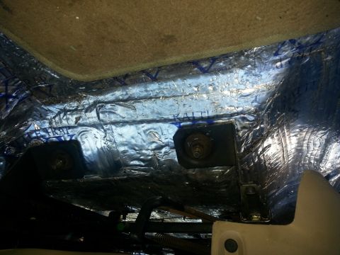 1994 Ford Bronco - The image shows the underside of a vehicle's interior, focusing on insulation and mounting hardware.