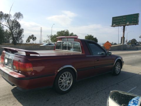 1968 Ford Mustang - This custom coupe utility vehicle features a spoiler and chrome accents, driving on a highway.