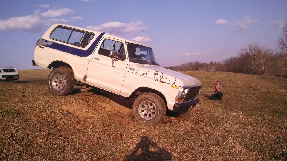 1979 Ford Bronco on grassy incline with another vehicle in background