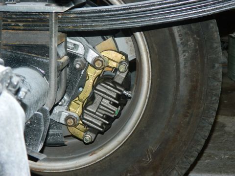 1979 Ford Bronco - Close-up of a vehicle's rear brake caliper and suspension components.