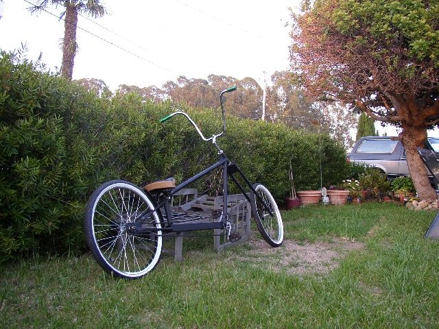 Custom black stretch chopper bicycle with ape-hanger bars on grass