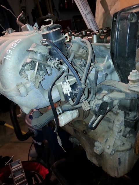 1991 Ford Festiva - Close-up view of engine parts, including intake manifold and valve cover.