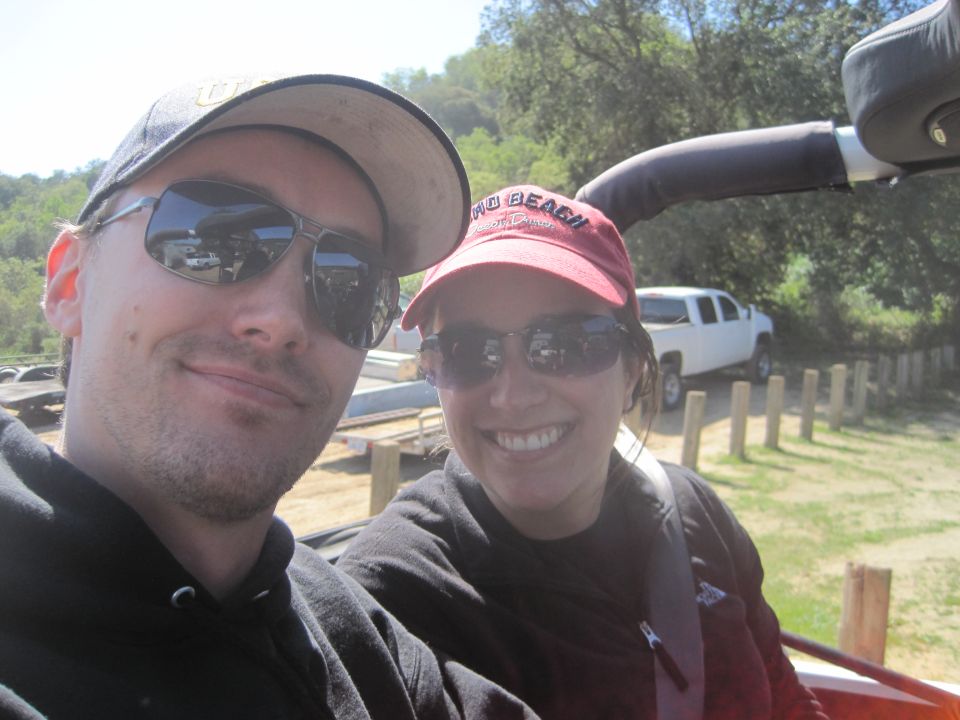 guy in cap and sunglasses, girl in red cap and sunglasses, white pickup truck in background