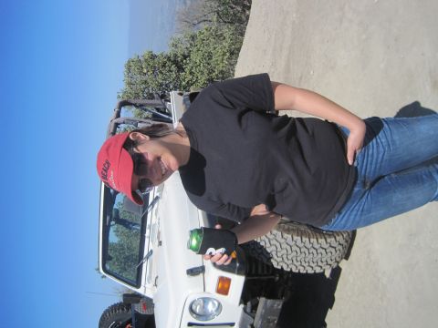 1989 Ford Bronco - A woman in a red hat and black shirt stands next to a white Jeep Wrangler.