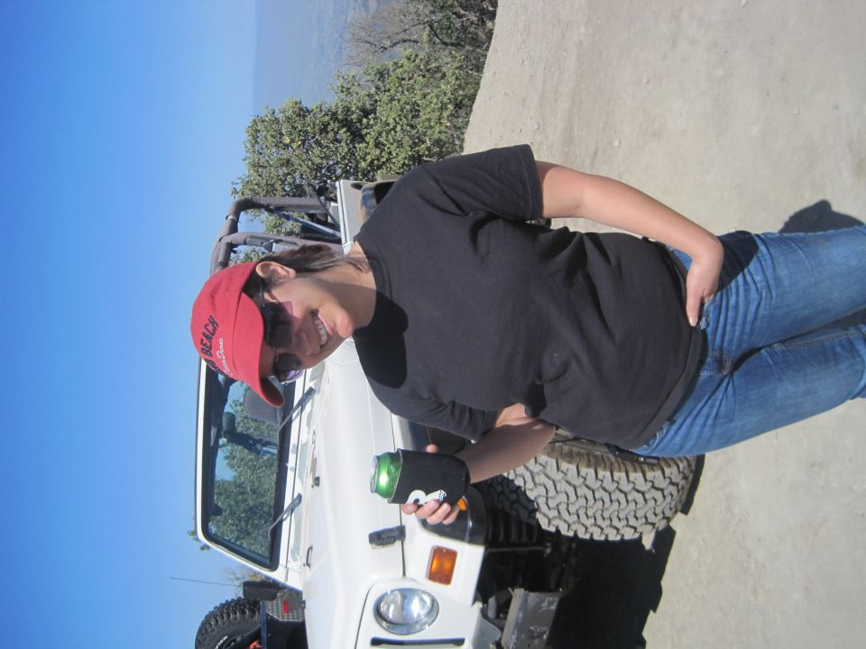 White Jeep Wrangler with a woman in a red hat and black shirt