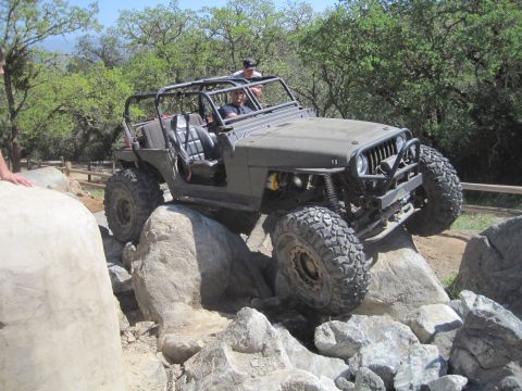 1989 Ford Bronco - This modified Jeep Wrangler is tackling a challenging rock crawling course.