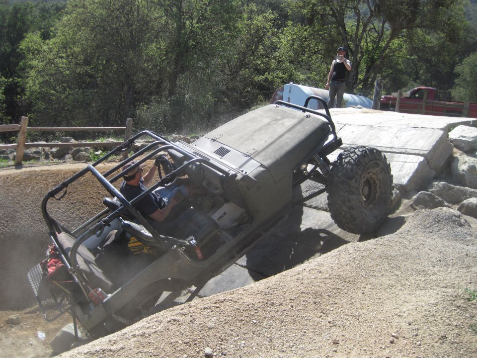 Jeep Wrangler on its side going over an obstacle