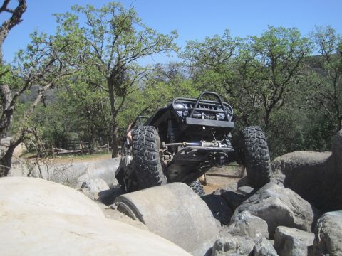 1989 Ford Bronco - An off-road vehicle navigates a rocky terrain, with its large tires gripping the obstacles.
