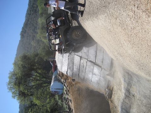 1989 Ford Bronco - An off-road vehicle navigates a steep, dusty incline on a sunny day.