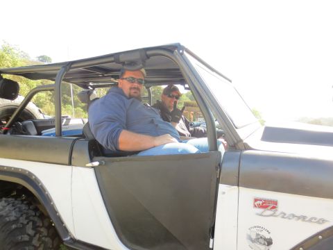 1989 Ford Bronco - Two men are seated inside a 1989 Ford Bronco, ready for an off-road adventure.
