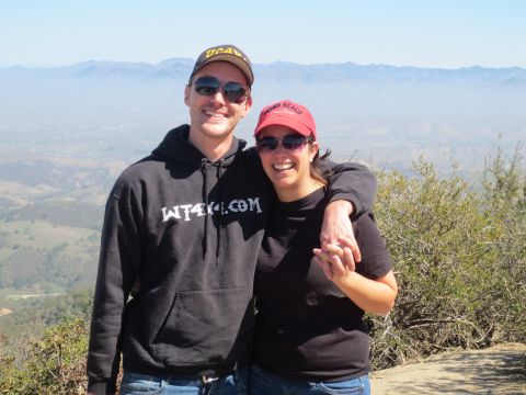 1989 Ford Bronco - A couple poses for a photo on a hilltop with a hazy valley and mountains in the background.