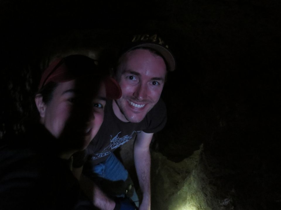 Two people smiling in a dark cave