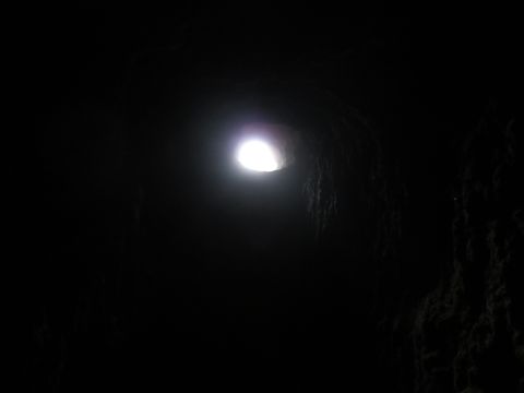 1989 Ford Bronco - A bright light emanates from a hole in a dark, cavernous space.
