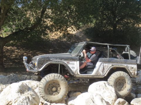 1989 Ford Bronco - This heavily modified first-generation Ford Bronco is shown tackling a challenging rocky trail.