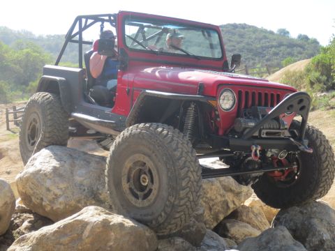 1989 Ford Bronco - This modified Jeep Wrangler is navigating a challenging rocky terrain.