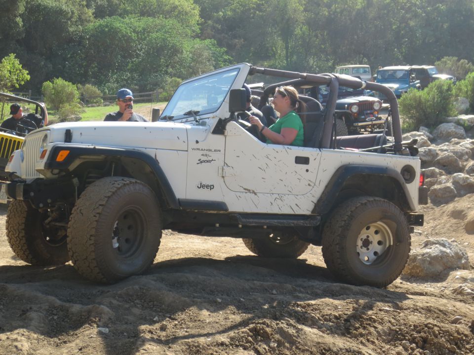 White Jeep Wrangler with mud splatters, side view