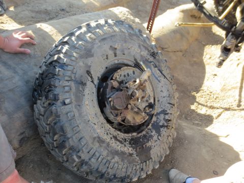 1989 Ford Bronco - This image shows a close-up view of a muddy off-road tire and its associated suspension components, suggesting a vehicle in a environment.