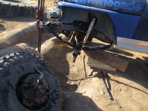 1989 Ford Bronco - Off-road vehicle undergoing suspension repair with a jack and tools nearby.