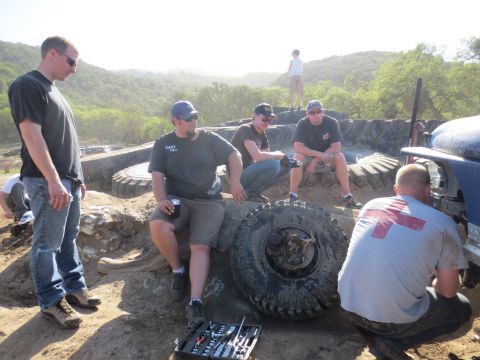 1989 Ford Bronco - A group of people are gathered around a vehicle, appearing to be in the middle of a repair or modification.
