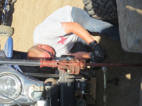1989 Ford Bronco - A person is seen working on the engine of a vehicle, with a focus on the mechanical components and tools.