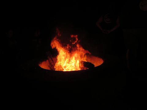 1989 Ford Bronco - A bright bonfire burns in a dark outdoor area, with indistinct figures visible in the background.