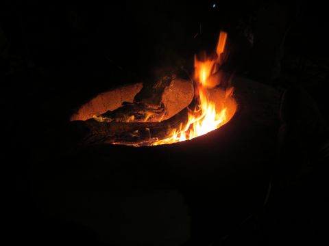 1989 Ford Bronco - A fire pit glows with bright orange flames and burning logs in the darkness.
