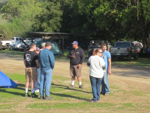 1989 Ford Bronco - People socializing at a campsite with tents and vehicles in the background.