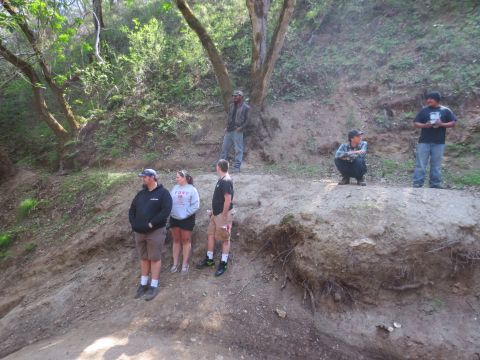 1989 Ford Bronco - A group of people are gathered on a hillside, observing something out of frame.